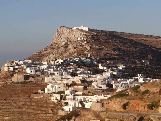 The sun sets over the houses of Kastro and the monastery of Zoodochou Pigis in Sikinos